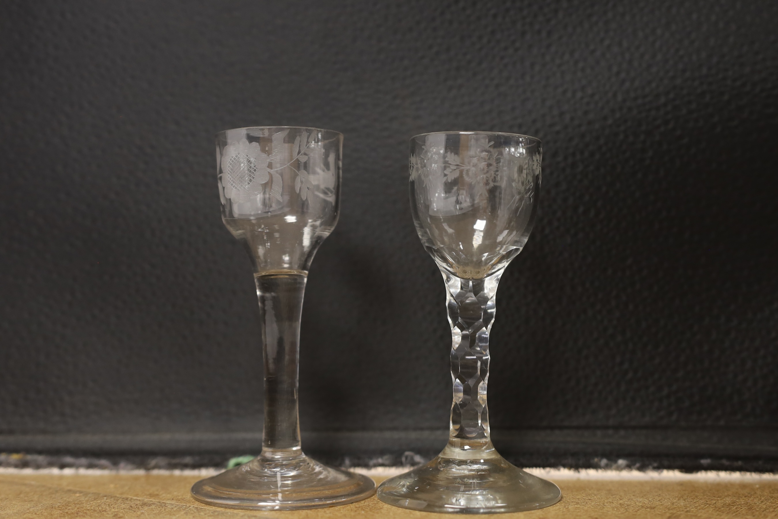 Two mid-18th century cordial glasses, each with wheel engraved decoration to the bowl, on a folded foot, together with a facet stem glass with engraved bowl, c.1780, tallest 13.5cm (3)